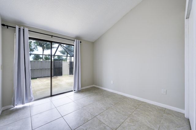 unfurnished room with vaulted ceiling, light tile patterned floors, baseboards, and a textured ceiling