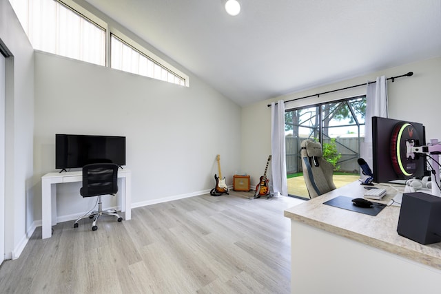 office with light wood-style floors, high vaulted ceiling, and baseboards