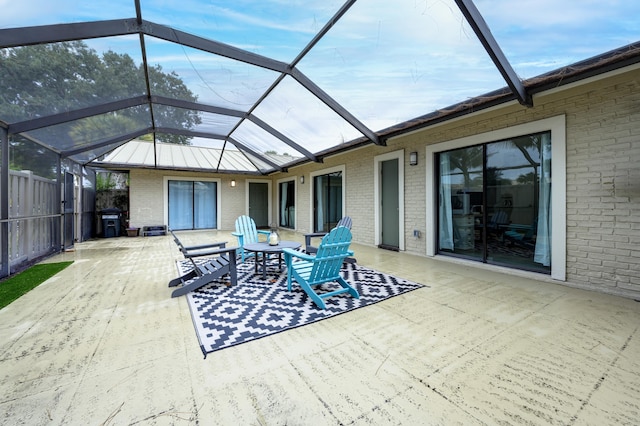 view of patio / terrace with a lanai and fence