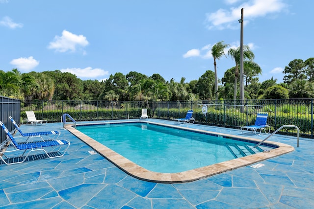 community pool featuring a patio and fence