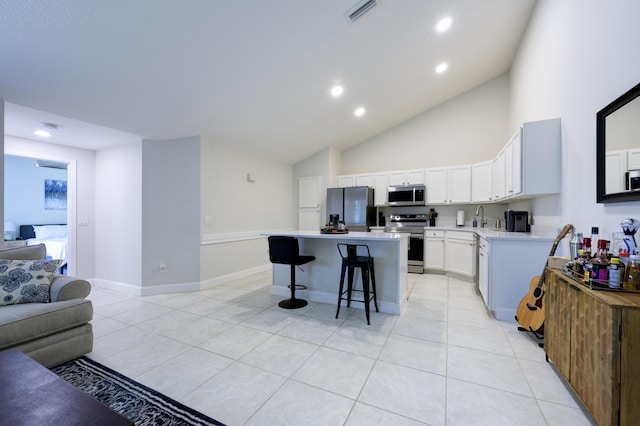 kitchen featuring stainless steel appliances, open floor plan, a sink, light tile patterned floors, and recessed lighting