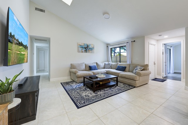living area with light tile patterned floors, baseboards, and high vaulted ceiling
