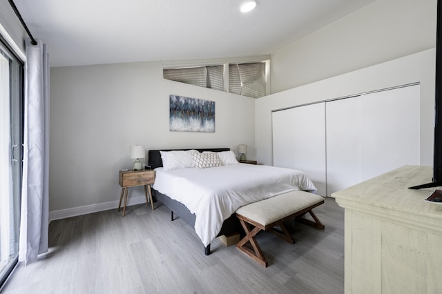 bedroom featuring wood finished floors, a closet, baseboards, and recessed lighting
