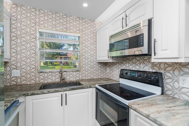 1150 NW 13th St Unit 172C, Boca Raton, FL 33486 - kitchen featuring stainless steel microwave, range with electric cooktop, a sink, white cabinets, and backsplash