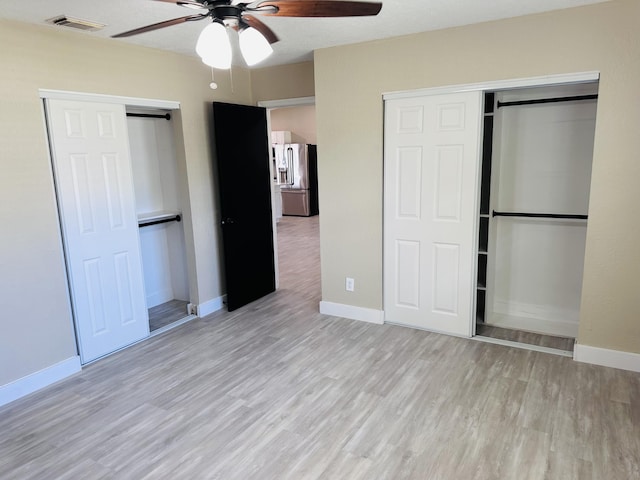 574 NW Marion Ave, Port Saint Lucie, FL 34983 - unfurnished bedroom featuring stainless steel fridge, wood finished floors, baseboards, and ceiling fan