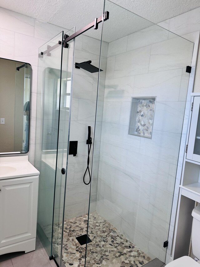 574 NW Marion Ave, Port Saint Lucie, FL 34983 - full bath featuring a shower stall, a textured ceiling, vanity, and toilet