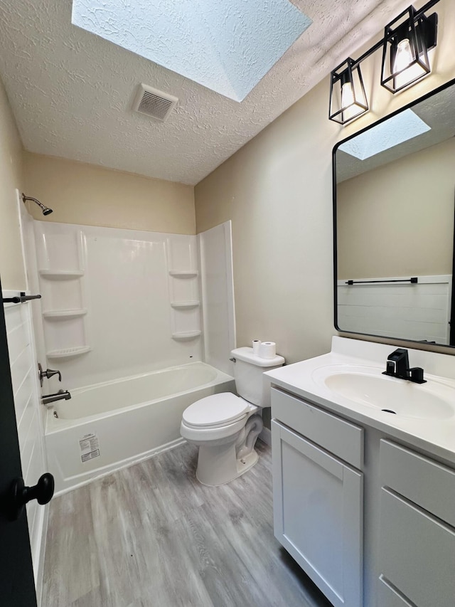 574 NW Marion Ave, Port Saint Lucie, FL 34983 - full bath with wood finished floors, toilet, vanity,  shower combination, and a textured ceiling
