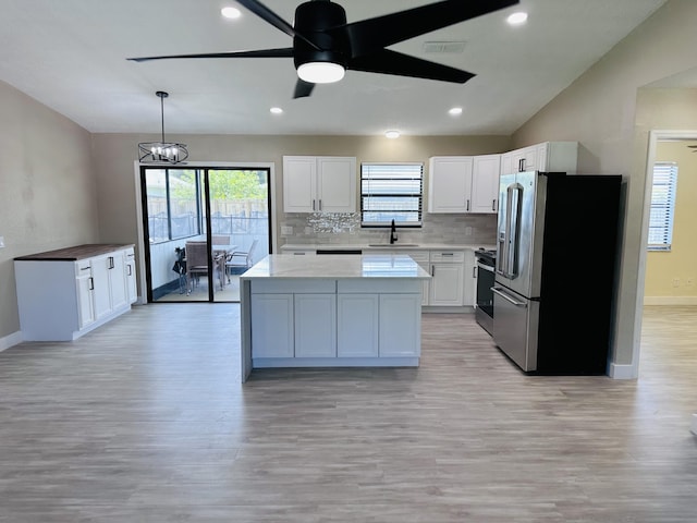 574 NW Marion Ave, Port Saint Lucie, FL 34983 - kitchen featuring stainless steel appliances, a sink, baseboards, light countertops, and plenty of natural light