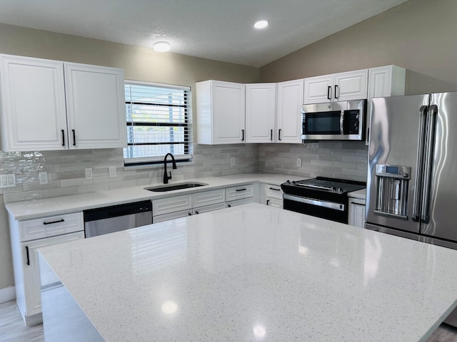574 NW Marion Ave, Port Saint Lucie, FL 34983 - kitchen featuring appliances with stainless steel finishes, a sink, light stone countertops, white cabinets, and tasteful backsplash