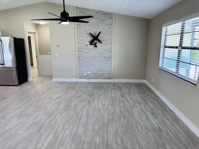 unfurnished living room featuring wood finished floors, ceiling fan, vaulted ceiling, and baseboards
