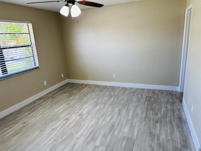 unfurnished room featuring light wood finished floors, ceiling fan, and baseboards