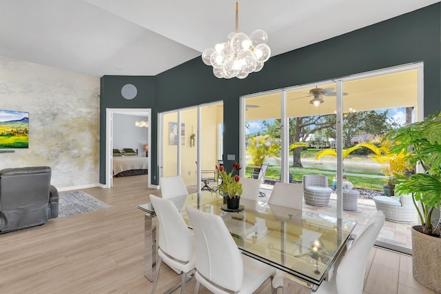 7816 Red River Rd, West Palm Beach, FL 33411 - dining area featuring a chandelier, light wood-style flooring, baseboards, and lofted ceiling