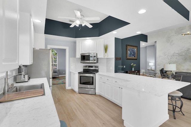 7816 Red River Rd, West Palm Beach, FL 33411 - kitchen featuring stainless steel appliances, a peninsula, white cabinets, a ceiling fan, and recessed lighting