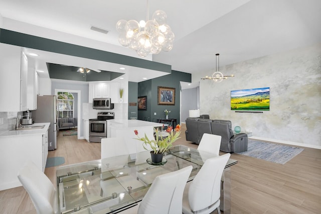 7816 Red River Rd, West Palm Beach, FL 33411 - dining area with a chandelier, light wood-type flooring, baseboards, and a ceiling fan