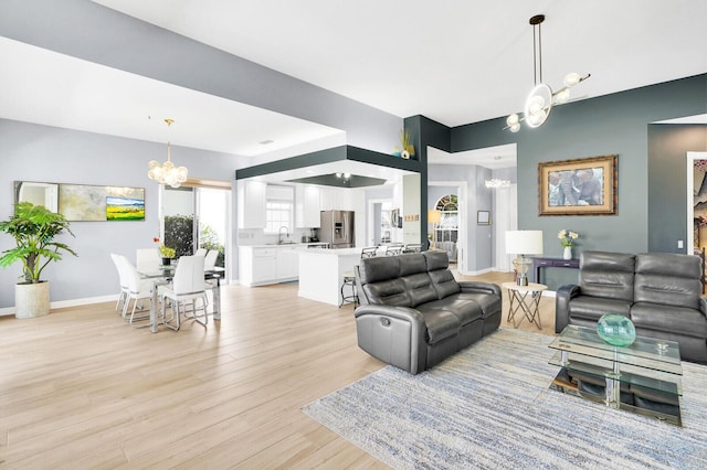 7816 Red River Rd, West Palm Beach, FL 33411 - living room featuring a chandelier, light wood-style floors, and baseboards