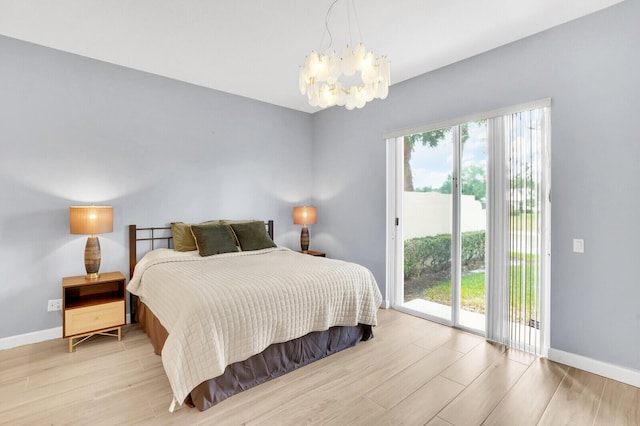 7816 Red River Rd, West Palm Beach, FL 33411 - bedroom featuring access to exterior, a chandelier, light wood-style floors, and baseboards