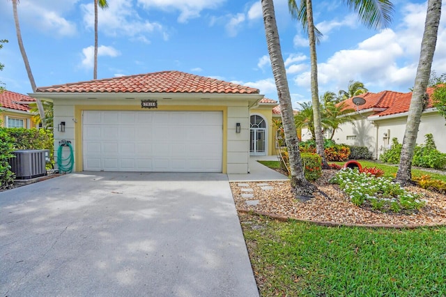 7816 Red River Rd, West Palm Beach, FL 33411 - mediterranean / spanish-style house with central air condition unit, a tile roof, an attached garage, and stucco siding