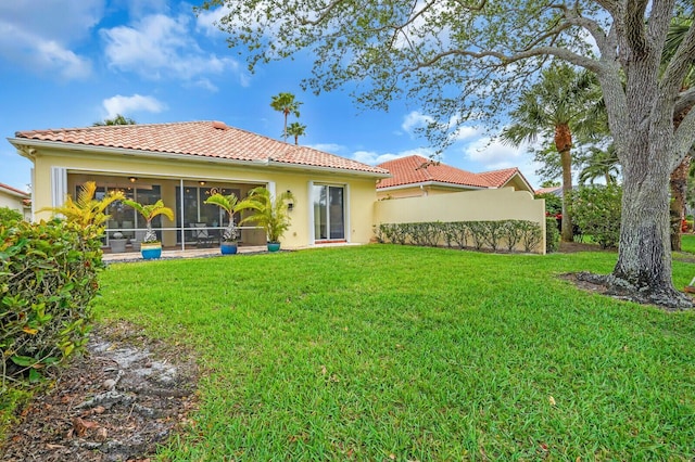 7816 Red River Rd, West Palm Beach, FL 33411 - rear view of house with a tiled roof, a yard, stucco siding, and a sunroom