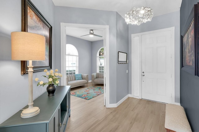 7816 Red River Rd, West Palm Beach, FL 33411 - entryway featuring light wood-style floors, baseboards, ceiling fan, and a chandelier