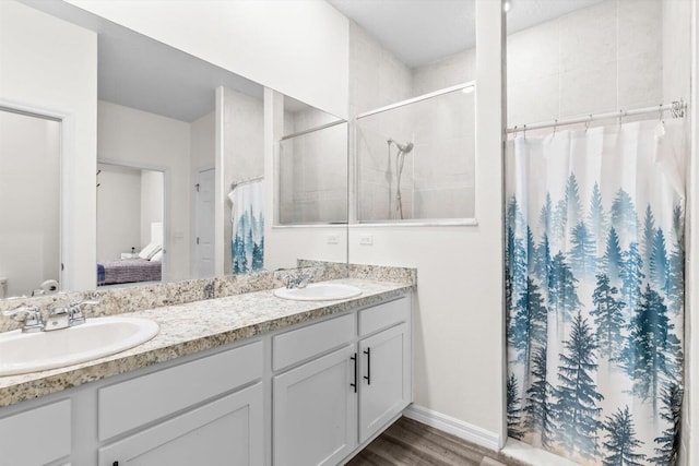 2509 SW Kenilworth St, Port Saint Lucie, FL 34953 - full bath featuring connected bathroom, double vanity, a tile shower, wood finished floors, and baseboards