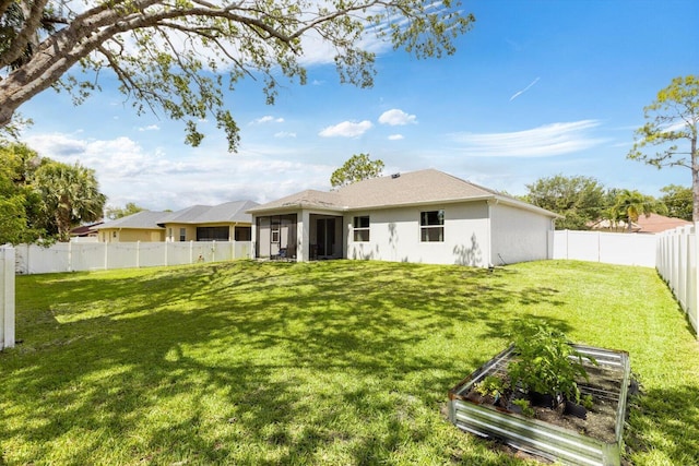 2509 SW Kenilworth St, Port Saint Lucie, FL 34953 - rear view of property with a garden, a sunroom, and stucco siding