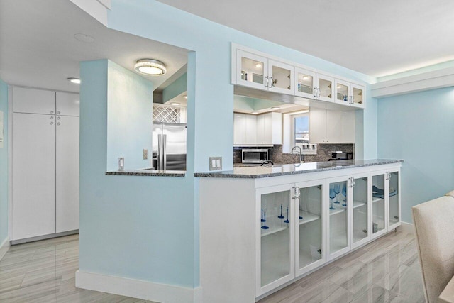 3000 S Ocean Blvd Unit 6010, Boca Raton, FL 33432 - kitchen featuring stainless steel appliances, tasteful backsplash, stone countertops, baseboards, and glass insert cabinets