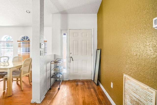 9023 Seminole Pratt Whitney Rd, The Acreage, FL 33470 - foyer entrance featuring a textured ceiling, wood finished floors, and a textured wall