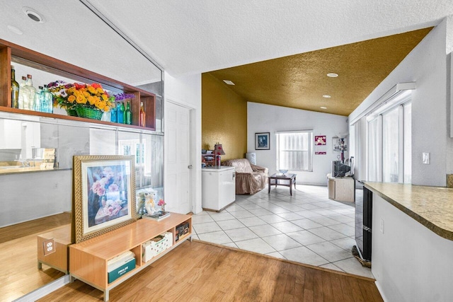 9023 Seminole Pratt Whitney Rd, The Acreage, FL 33470 - interior space with vaulted ceiling, a textured ceiling, and light wood-type flooring