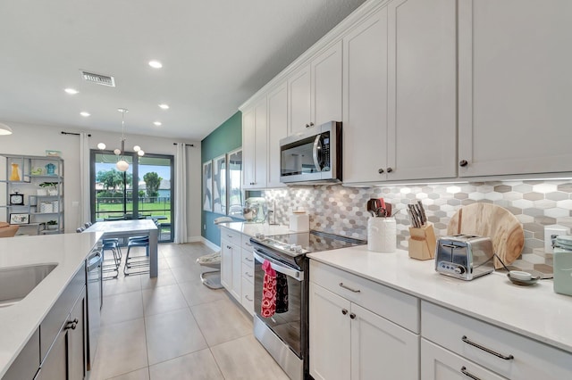4646 Eventing St, Lake Worth, FL 33467 - kitchen featuring stainless steel appliances, decorative backsplash, light countertops, light tile patterned floors, and recessed lighting