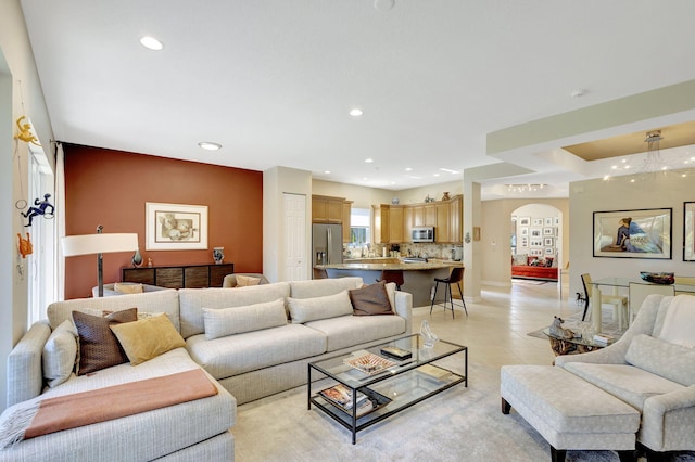 living room featuring arched walkways, recessed lighting, light tile patterned flooring, and baseboards