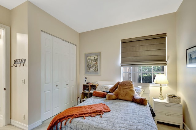 bedroom featuring light carpet, a closet, and baseboards
