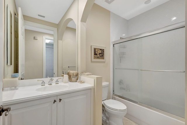 bathroom with toilet, vanity, and combined bath / shower with glass door