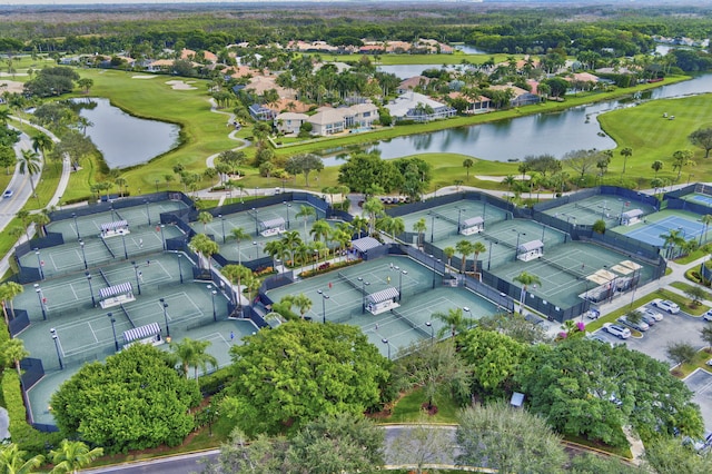 aerial view of property and surrounding area with a local golf course, a nearby body of water, and nearby suburban area
