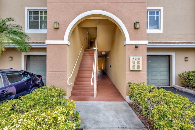 6510 Emerald Dunes Dr Unit 302, West Palm Beach, FL 33411 - entrance to property with stucco siding and an attached garage