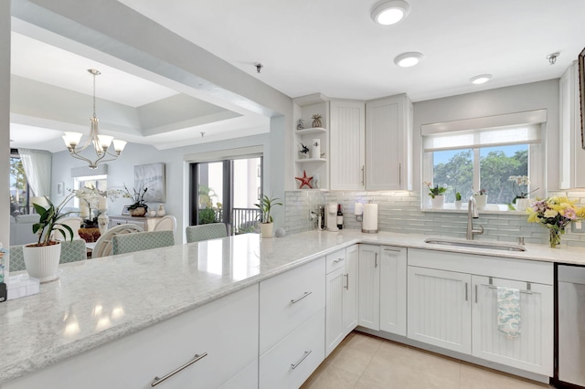 kitchen with a sink, dishwasher, tasteful backsplash, and plenty of natural light