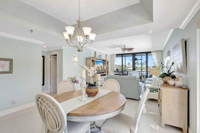dining room featuring a chandelier, crown molding, baseboards, a raised ceiling, and a ceiling fan