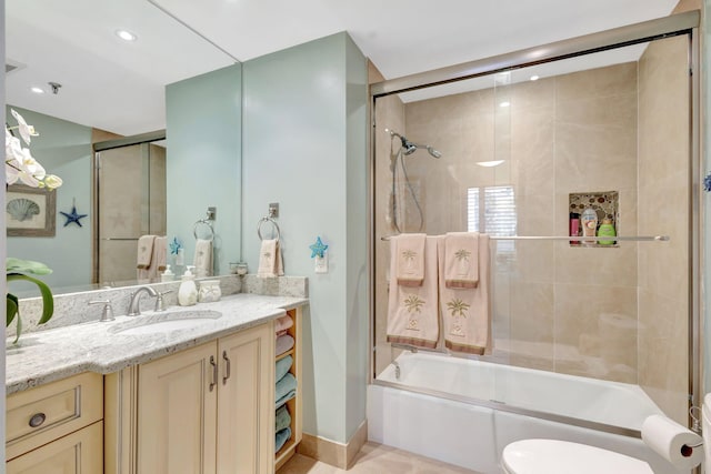 full bathroom featuring toilet, vanity, shower / bath combination with glass door, and baseboards
