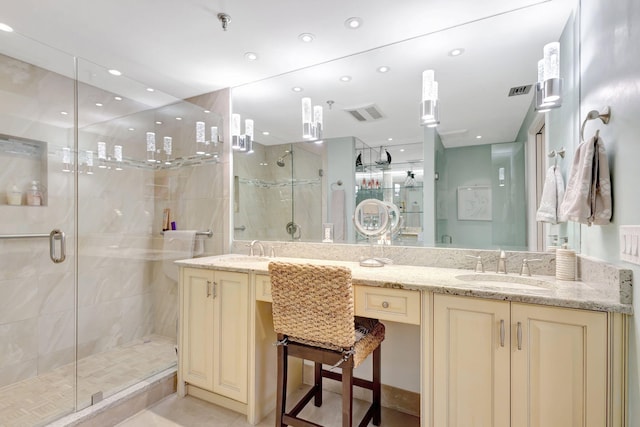 bathroom with a shower stall and double vanity
