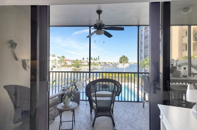 balcony with a water view and a ceiling fan