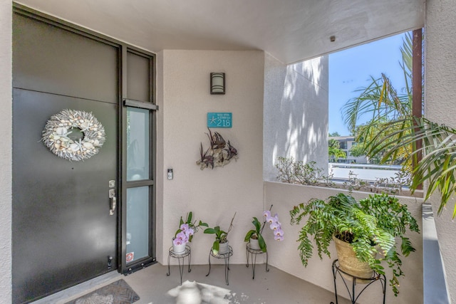 property entrance featuring stucco siding and a balcony