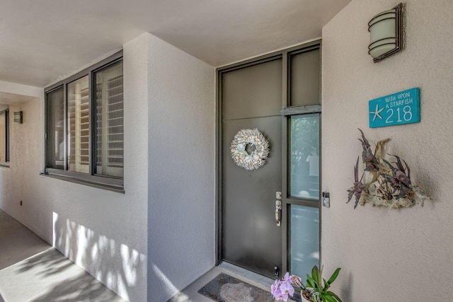 entrance to property featuring stucco siding