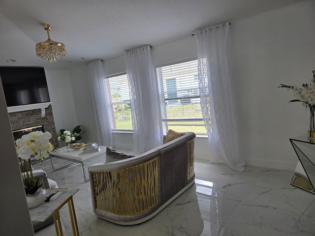 dining area featuring light marble finish floors, a fireplace, and baseboards