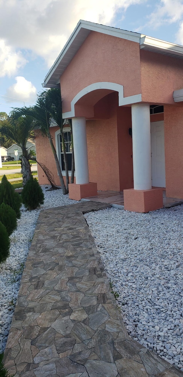 doorway to property featuring stucco siding