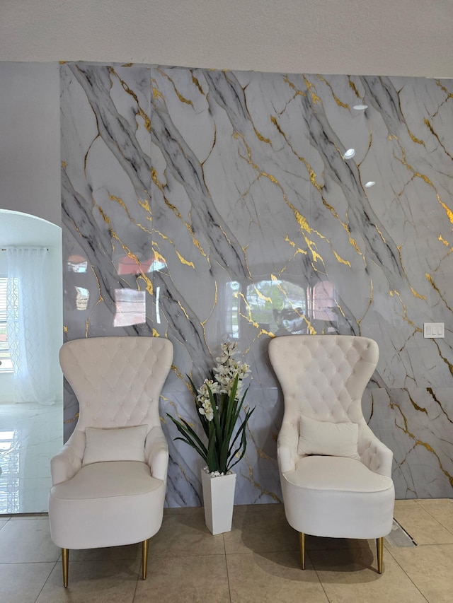 living area with stone wall and tile patterned floors
