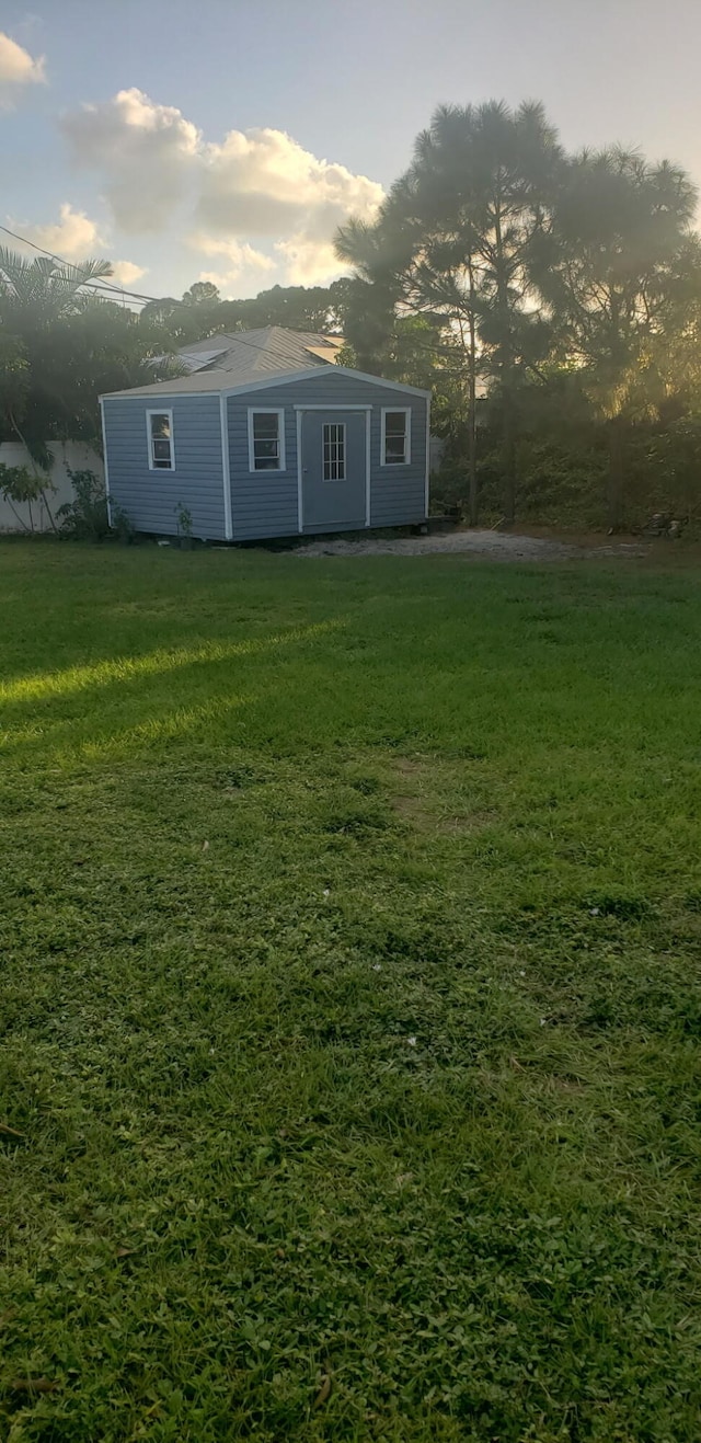 view of front facade featuring a front yard and an outdoor structure