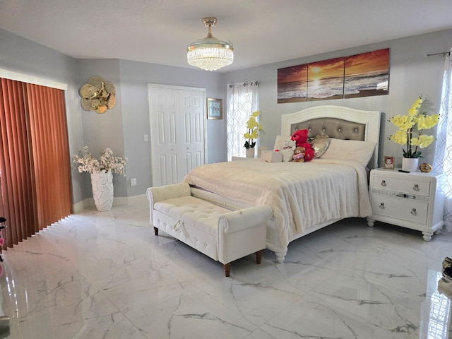 bedroom with marble finish floors, baseboards, and a closet