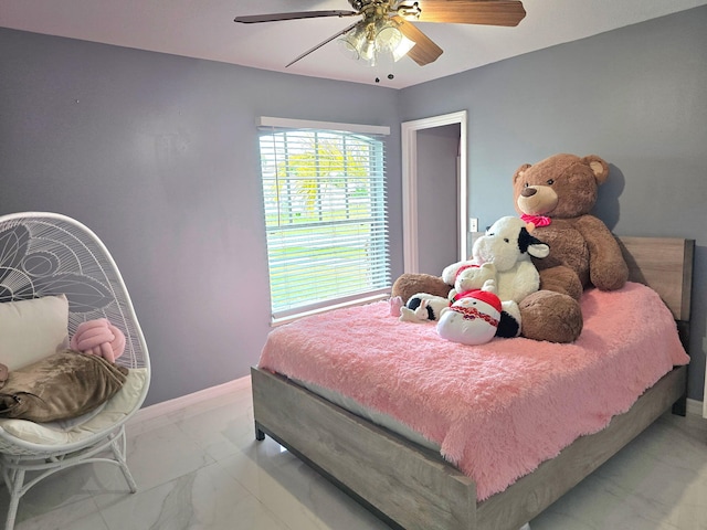 bedroom with marble look tile flooring, baseboards, and a ceiling fan