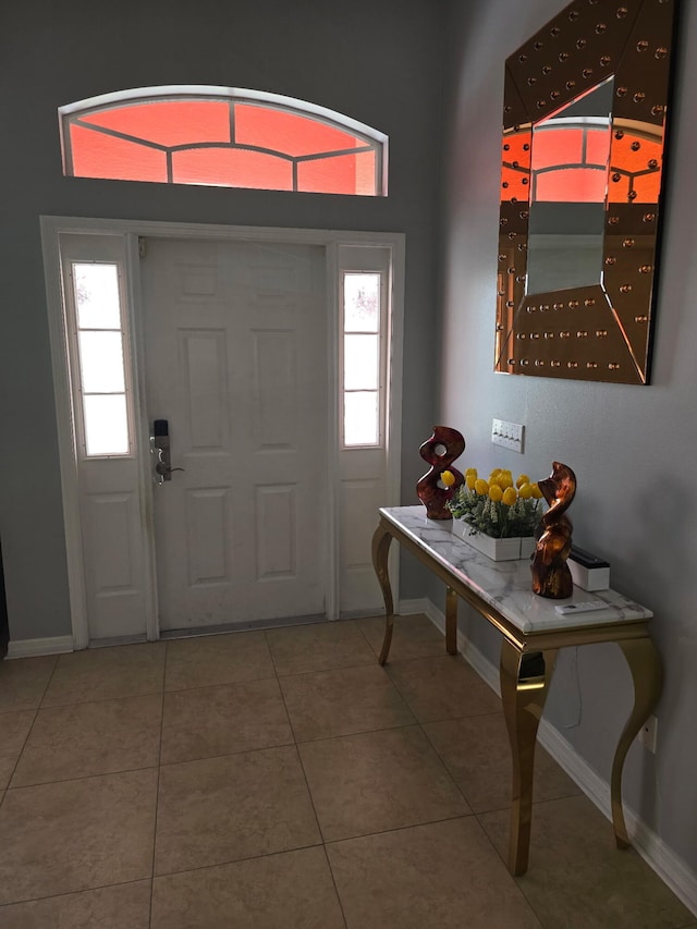 foyer entrance featuring baseboards and tile patterned flooring