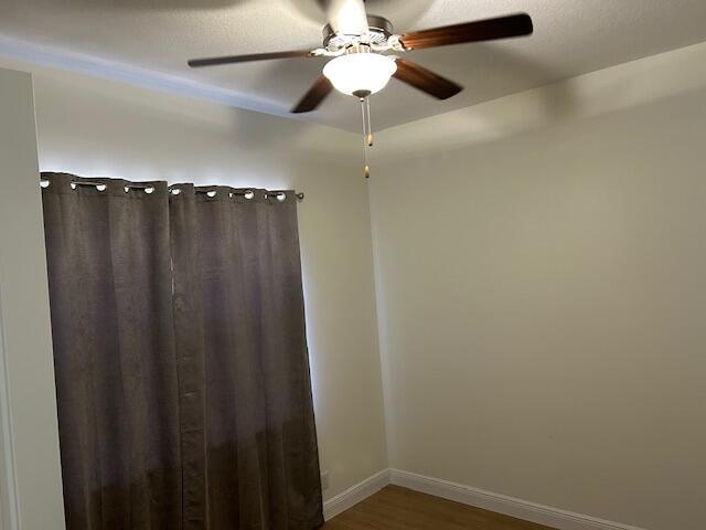 14413 71st Pl N, Loxahatchee, FL 33470 - unfurnished room with wood finished floors, baseboards, and a ceiling fan