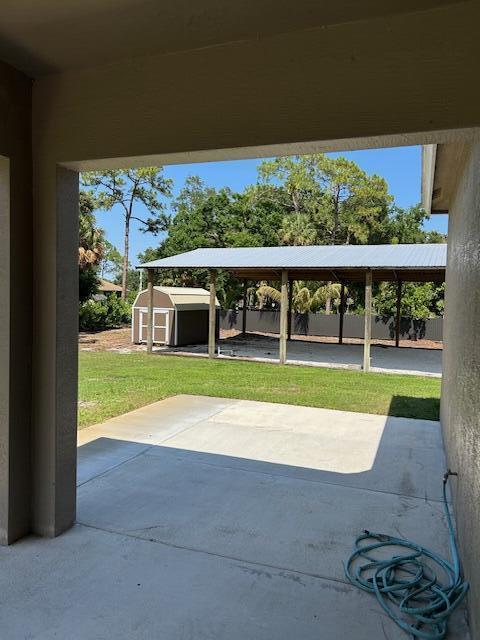14413 71st Pl N, Loxahatchee, FL 33470 - view of patio / terrace featuring a storage shed and an outbuilding